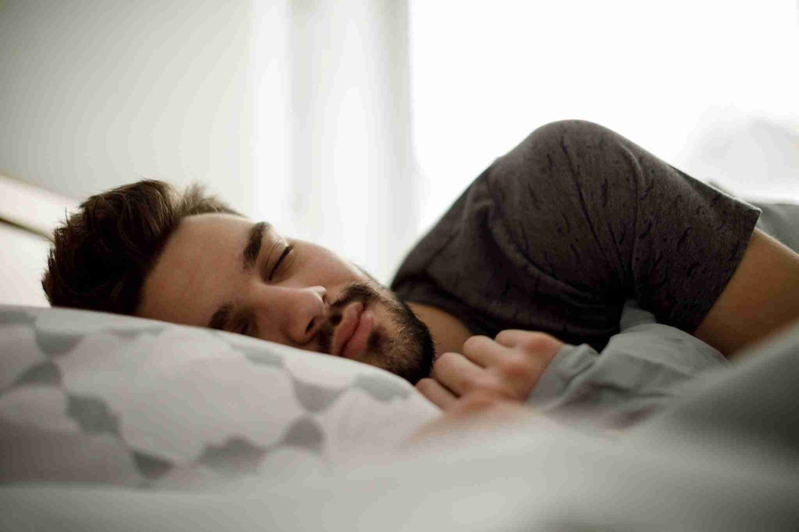 Young man sleeping in bed at home 