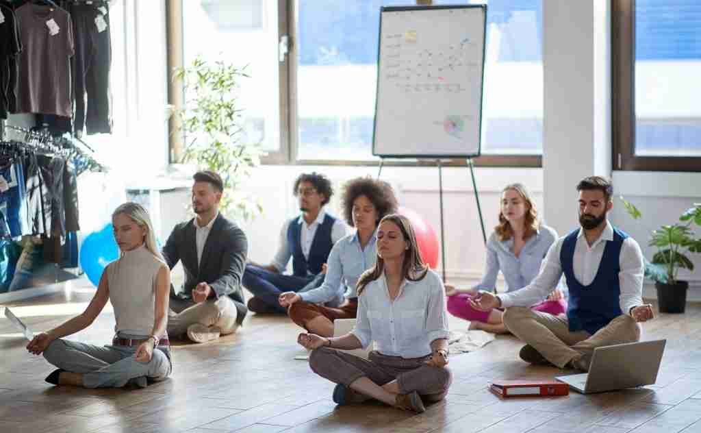 Business colleagues meditating at work