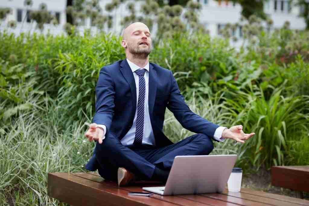 Businessman meditating in the park