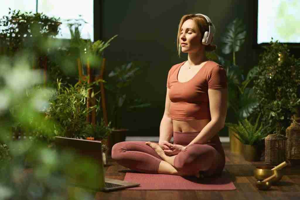 woman meditating in modern green house