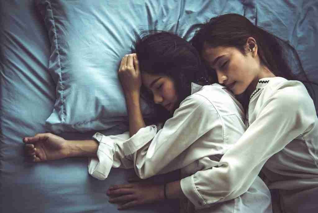 women napping on a bed together