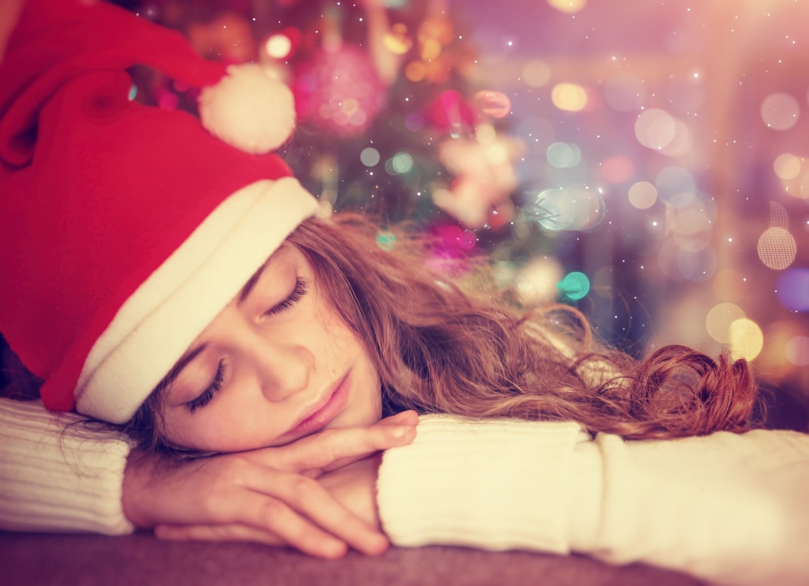 Teen girl sleeping near Christmas tree