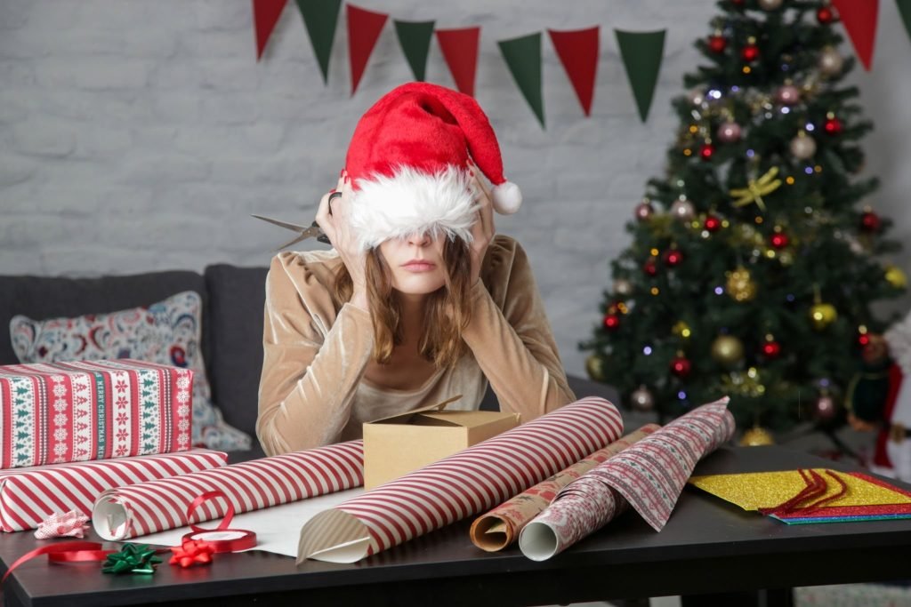 Frustrated woman wrapping Christmas gift