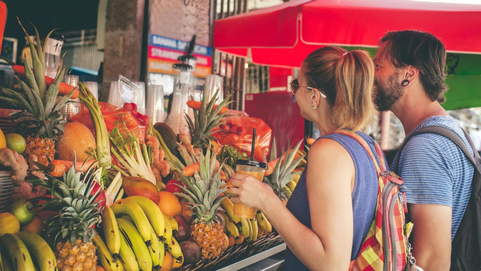 Photo of a colorful market stall, someone grocery shopping with a focus on fresh produce