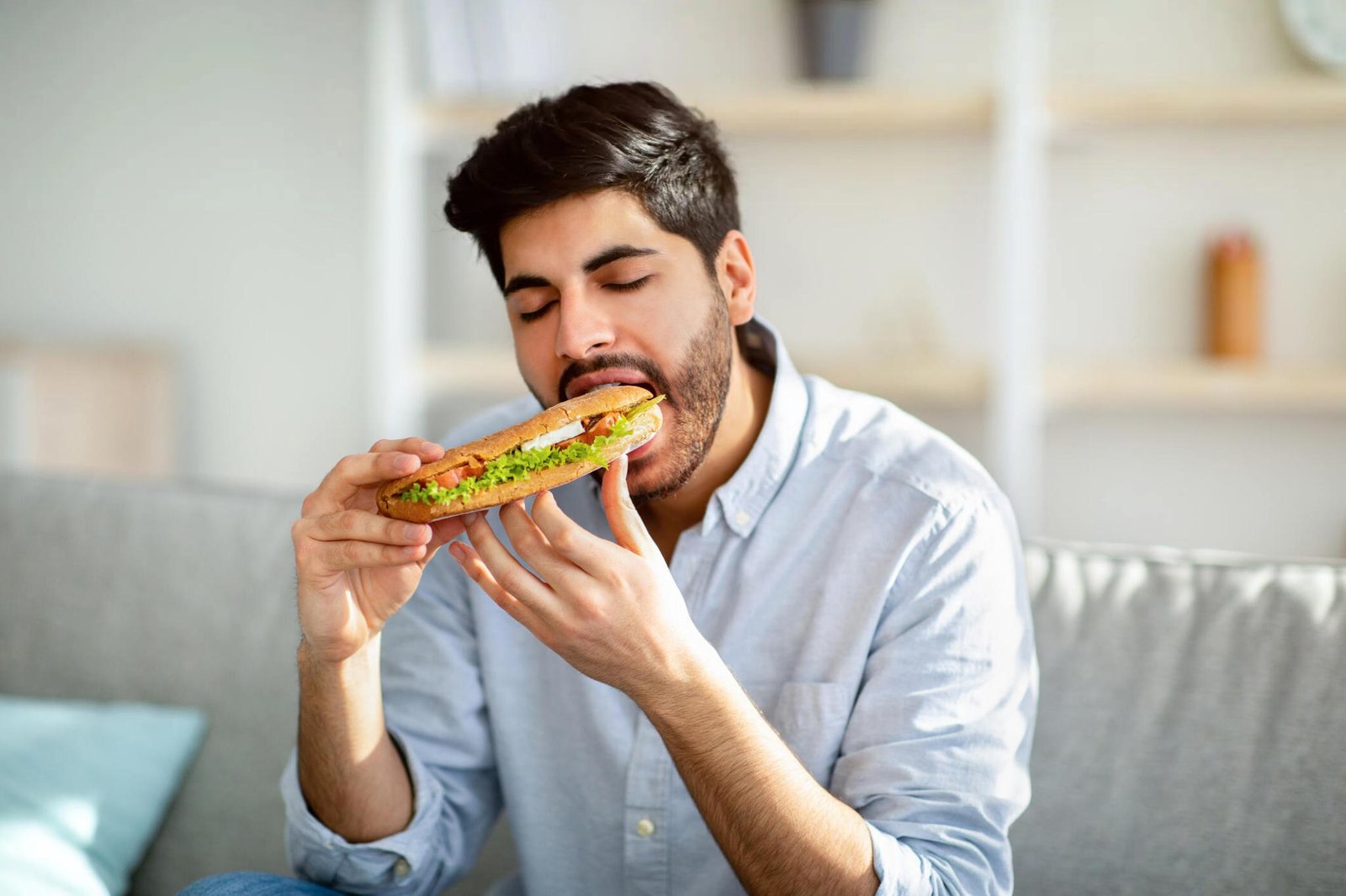 a person savoring a bite of food with their eyes closed
